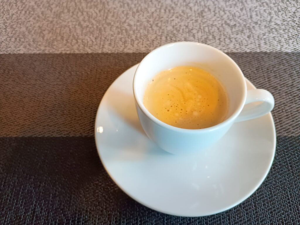 白いカップ＆ソーサーに注がれた、食後の本格コーヒー。琥珀色の液面にきめ細かな泡が立つ。