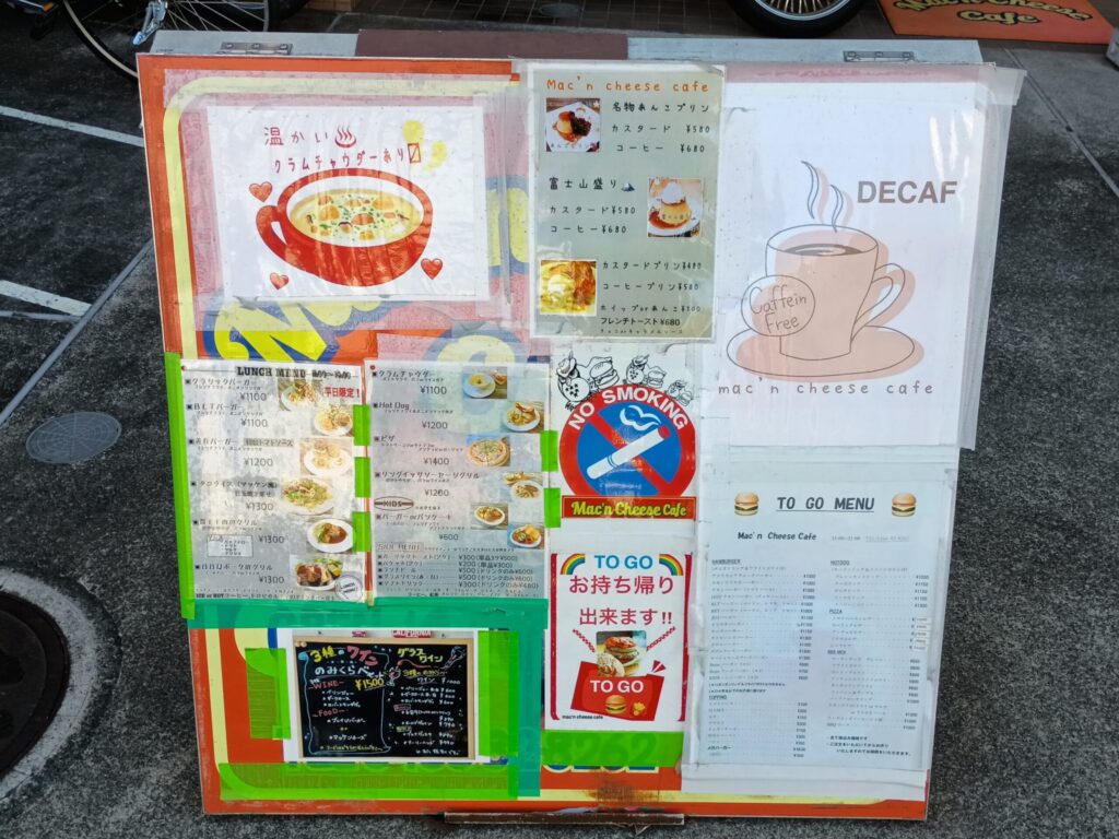（メニュー看板・外）
マッケンチーズカフェの店頭メニュー看板。ランチメニュー、名物あんこプリン、富士山盛り、クラムチャウダー、テイクアウトメニューなどが並ぶ